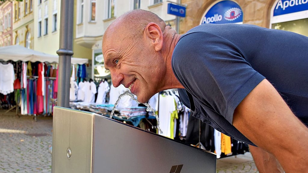 Michael Länger genießt das kühlende Nass aus dem Trinkwasserbrunnen am Zeitzer Roßmarkt.