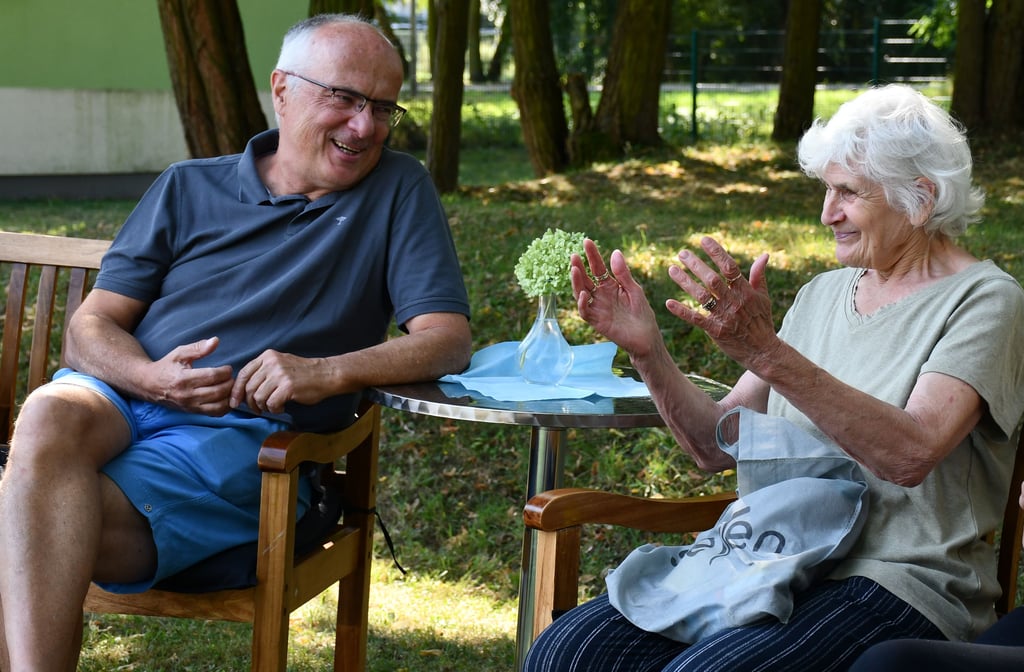 Apotheker Stefan Locke und Christa Pientka beim Gespräch auf der Gartenbank im Nachbarschaftszentrum in Magdeburg.