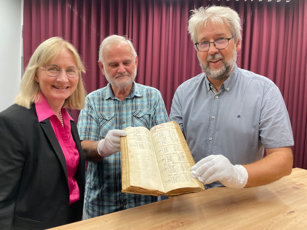 Halles Kulturbeigeordnete Judith Marquardt, der bisherige Eigentümer des Dokuments und Stadtarchivar Ralf Jacob (v.l.) präsentieren das handgeschriebene Original aus dem Dreißigjährigen Krieg. Nun gehört es zum Bestand des Stadtarchivs Halle.
