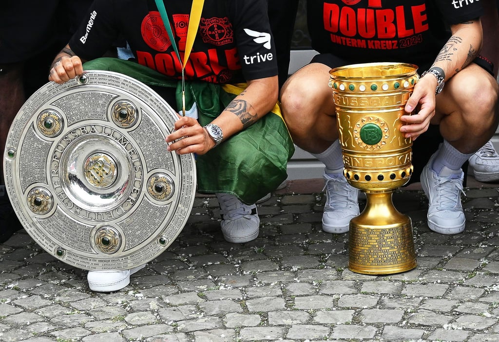 Hat sich Bayer-Boss Fernando Carro als Replik anfertigen lassen: die Meisterschale und den DFB-Pokal.