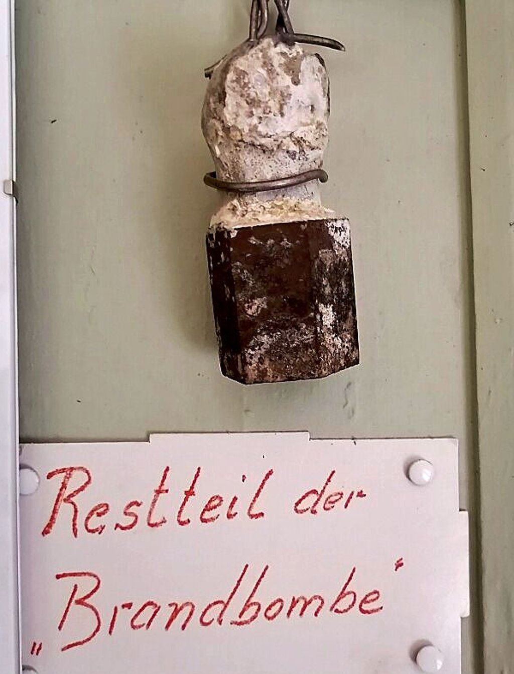 Ein Überrest der Brandbombe ist zur Mahnung bis heute vor Ort zu sehen.