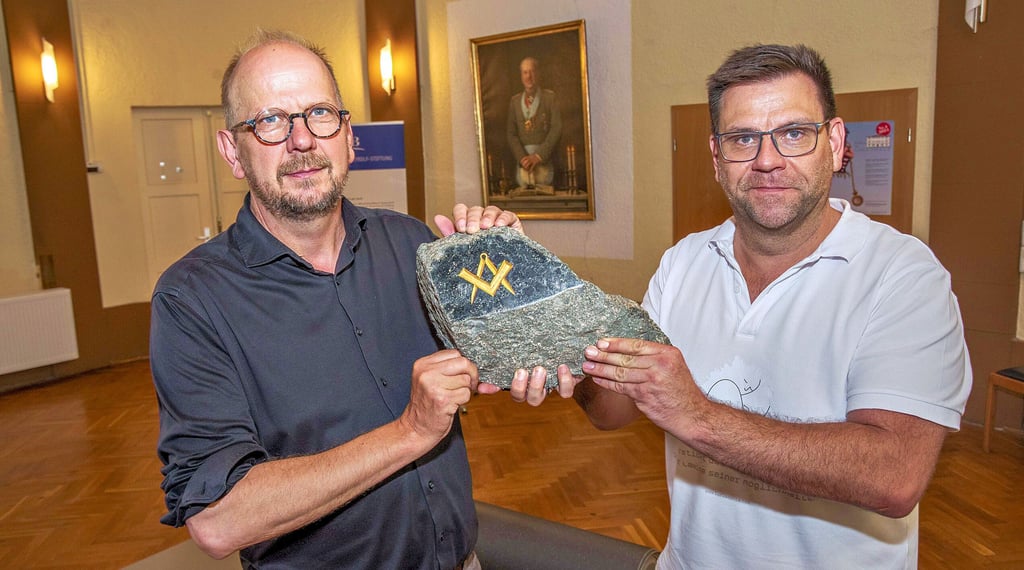 Uwe Dorand (l.), Meister vom Stuhl, und Logenbruder Frank Richter von der Freimaurerloge „Zu den drei Säulen“ halten den rauen Stein. Dieser ist ein Symbol und war vom Dessauer Steinmetz Fritz Melchert geschaffen worden.