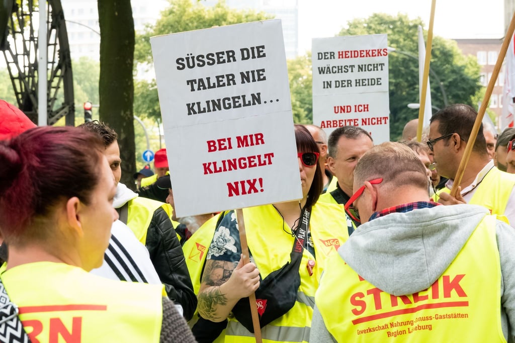 Beschäftigte der Süßwarenindustrie stehen während einer Kundgebung zusammen.
