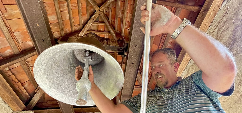 Tino Cebulski putzt die fast 200 Jahre alte Glocke des Dorfes, deren Herkunft unbekannt ist, für das bevorstehende Fest heraus.