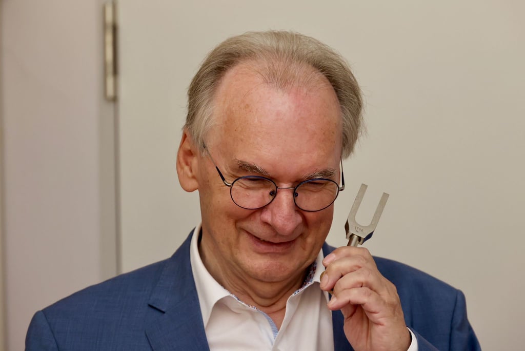 Haseloff, der Physik studiert hat, mit einer Stimmgabel, anhand derer Schüler im Physikunterricht etwas über Akustik, Schallwellen und Frequenz lernen.