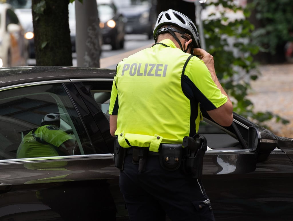 Ein Beamter der Fahrrad-Staffel der Berliner Polizei kontrolliert einen Pkw-Fahrer. (Symbolbild)