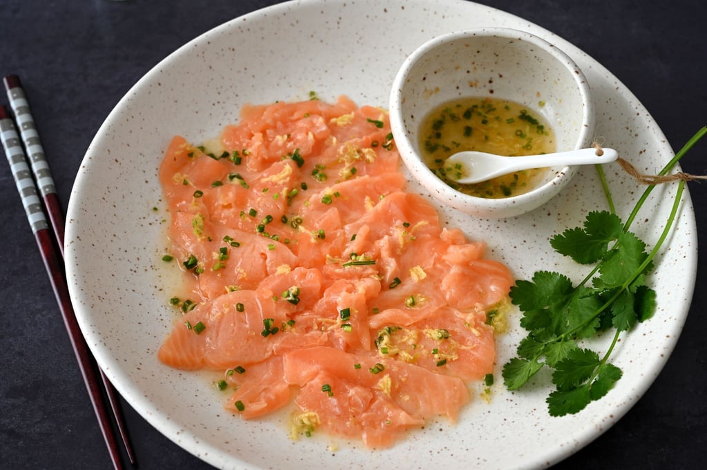 Wenn man das Lachs-Carpaccio mit dem asiatischen Dressing beträufelt, wird die Farbe des Fischs etwas heller.