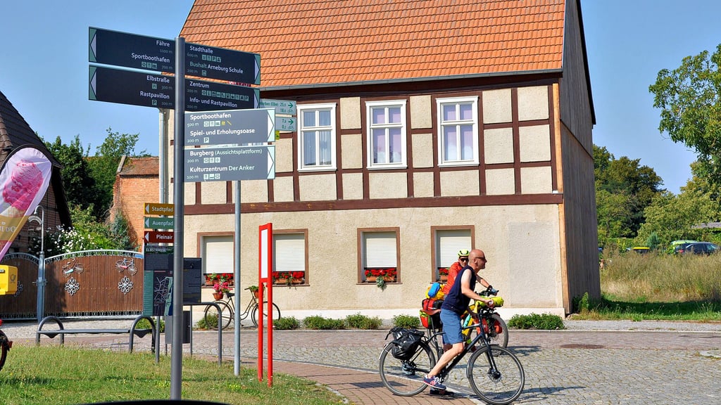 Radler überqueren die Kreuzung Tangermünder Straße/Elbstraße in Arneburg. Im Vordergrund einer von insgesamt 33 neuen Wegweisern.