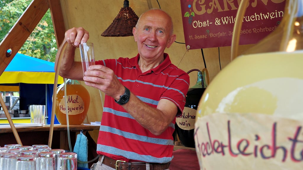 Helmut Sasse aus Rohrbeck bietet an seinem Stand  im Regionaldorf Alrmark auf dem Winckelmannplatz in Stendal selbsthergestellten Wein, Met und Saft an. 