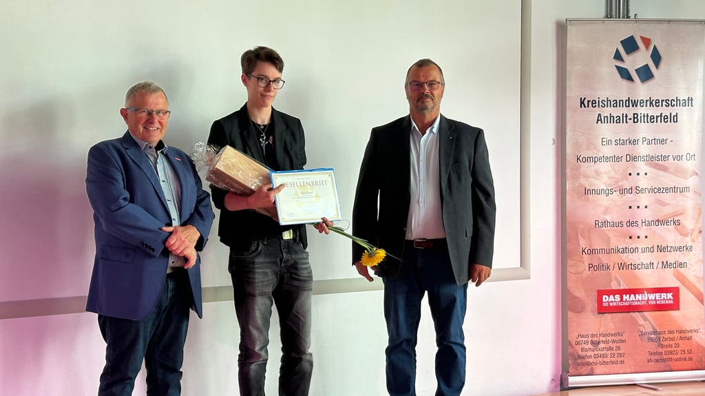 Kreishandwerksmeister Roland Prokop (l.) und Volker Pietrek, Obermeister der Holz- und Metall-Innung Anhalt-Zerbst, gratulieren der Jahrgangsbesten Tischlergesellin Lea Clasen.