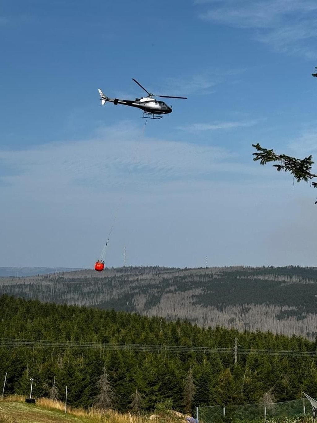 Kampf gegen den Waldbrand am Brocken im Harz: Ein Hubschrauber mit Löschwasser auf dem Weg zur Brandstelle am Königsberg.