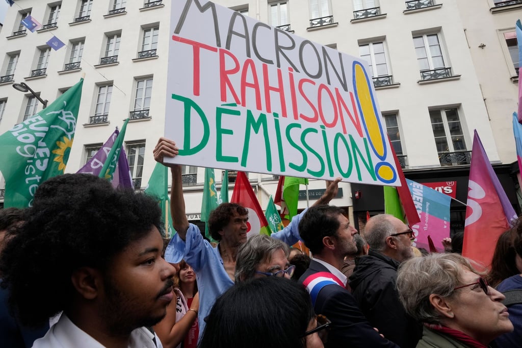 „Rücktritt von Macron - Verrat“ wird auf einem Plakat auf einer Demonstration in Paris gefordert.