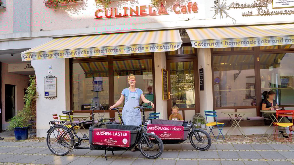 Michaela Fiedler und Sohn Jacob mit den beiden Lastenrädern vor dem Café Culinela in der Wittenberger Altstadt.