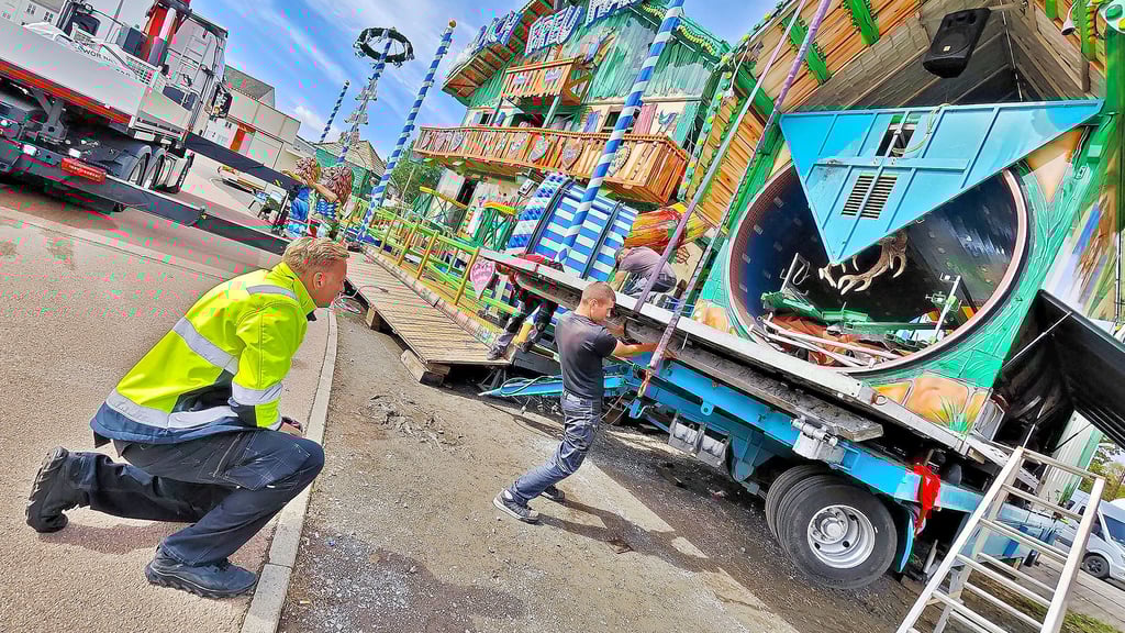 Der Magdeburger Schausteller Hendrik Boos (links) und seine Mitarbeiter bauen das „Lach+Freu-Haus“ auf, eine Neuheit auf der Wiese.