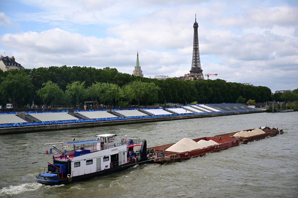 Keine Filmszene, sondern ein Foto aus dem Sommer während Olympia. Ein Schiff passiert Tribünen, im Hintergrund ist der Eiffelturm zu sehen. Im Netflix-Hit „Im Wasser der Seine“ treibt dagegen ein Hai sein Unwesen im Pariser Gewässer. (Archivbild)