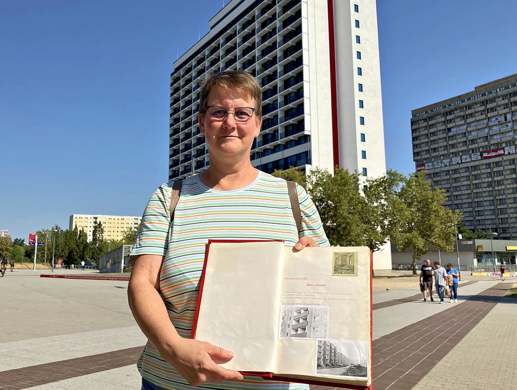 Lauter Erinnerungen aus der DDR, an eine Zeit in einem untergegangenen Land: Heike Leps zeigt das Hausklub-Buch, in dem das Zusammenleben in Haus 9 im Block 75 in Halle-Neustadt dokumentiert ist.