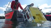 Bei der Erkundung des mittelalterlichen Prahms im Arendsee wird ein Tauchroboter von einem Boot der Wasserwacht Halle zu Wasser gelassen.