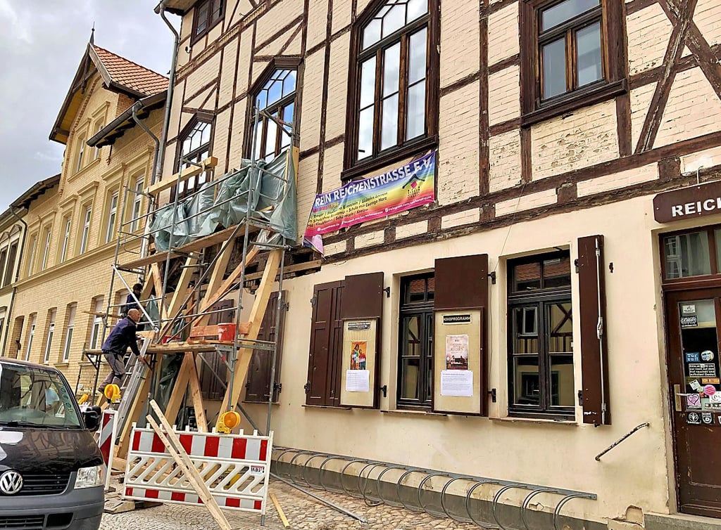 Stützbalken und ein Gerüst stehen an der Fassade des Hauses.