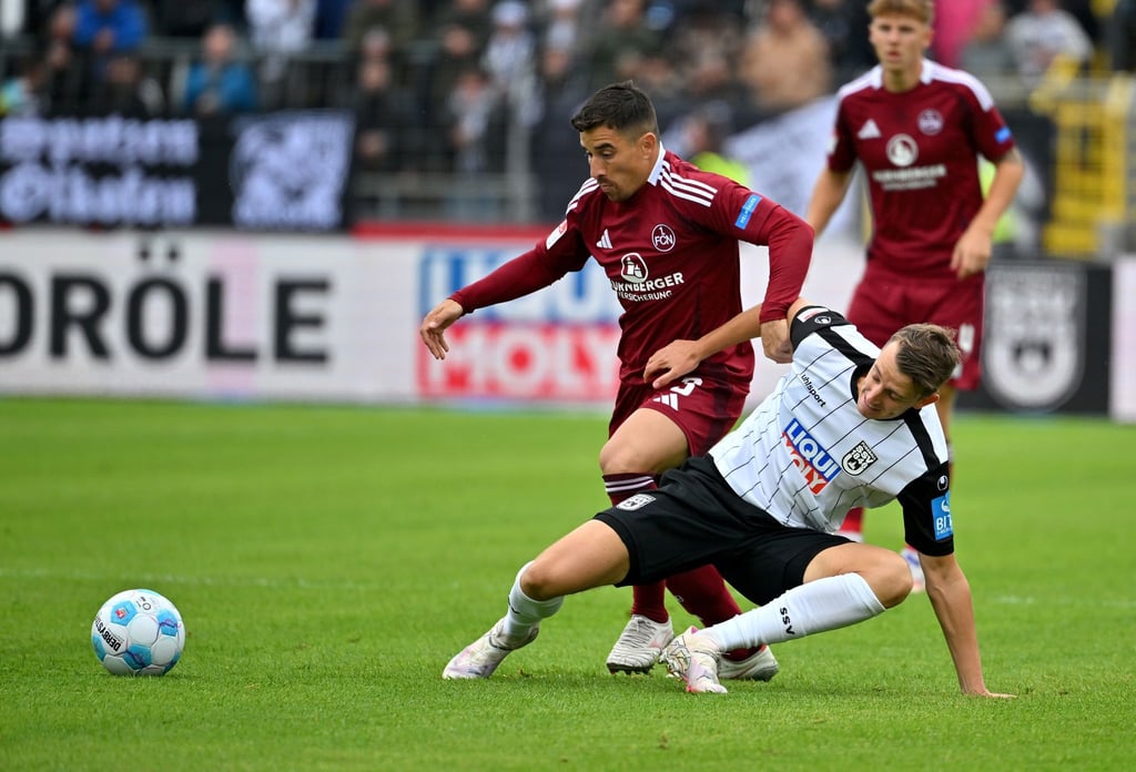 Nürnbergs Danilo Soares (links) kämpft gegen Ulms Lennart Stoll um den Ball.