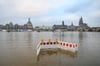 Absperrungen stehen gegenüber der Altstadtkulisse auf den von der Elbe überfluteten Elbwiesen in Dresden.