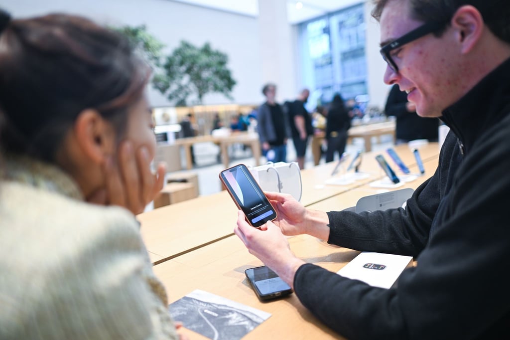 Dieser Mann ist einer der ersten Käufer des iPhone 16 in Deutschland. Gerade richtet er das Gerät im Apple Store in Berlin-Mitte ein.