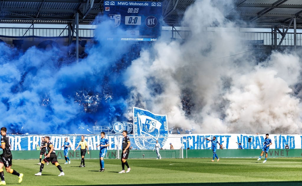 Die Magdeburger Fans zeigen ein fragwürdiges Banner und betonen dies mit Pyrotechnik.