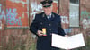 Dietmar Neubauer in seiner Eisenbahneruniform mit der Verdienstmedaille der Deutschen Reichsbahn auf dem heruntergekommenen Bahnhof Zielitz. 