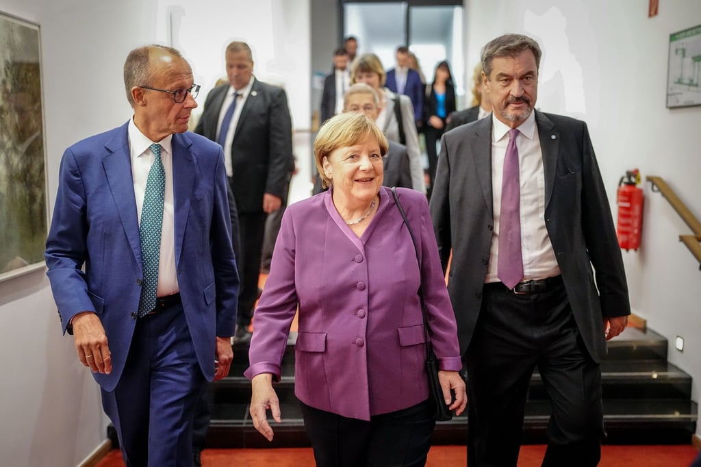 Markus Söder, CSU-Vorsitzender und Ministerpräsident von Bayern, und Friedrich Merz, CDU-Bundesvorsitzender und Unionsfraktionsvorsitzender, begleiteten Altkanzlerin Angela Merkel zu ihrem Platz.