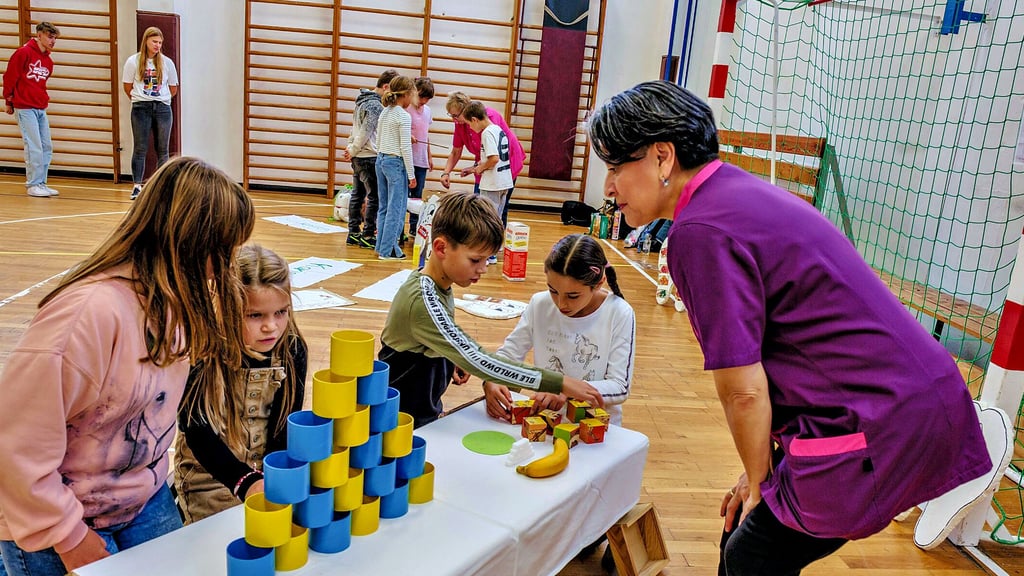 Schulzahnärztin Alma Bartlick betreut den Puzzlestand in der Turnhalle. Hier müssen die Kinder einen Zahn zusammensetzen und aus Dosen, auf denen Wörter stehen, einen sinnvollen Satz bilden.