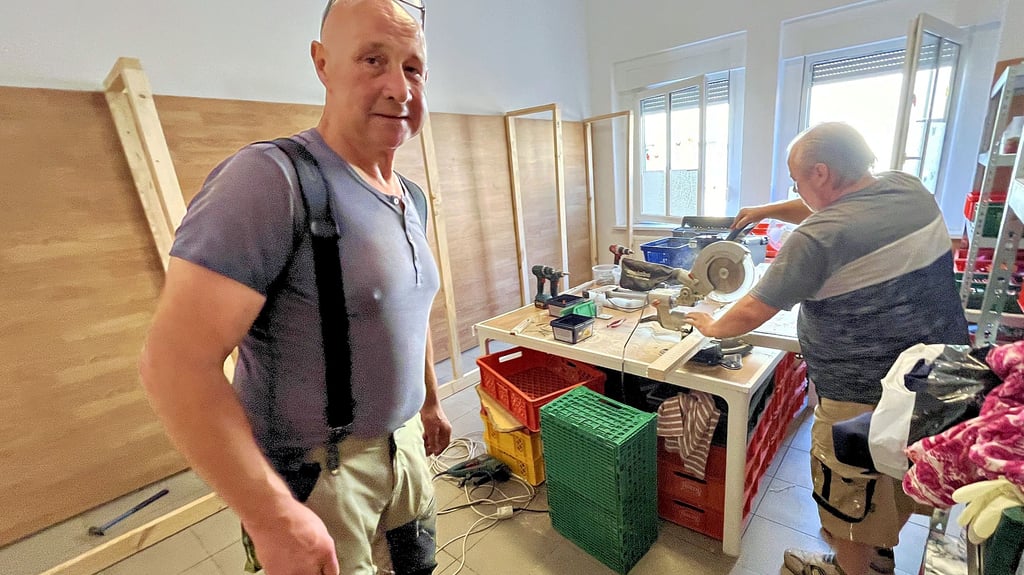 Thomas Brode und Klaus Rudolph zimmern Regale, die mehr Platz bieten und das Packen der Tafelkisten erleichtern.