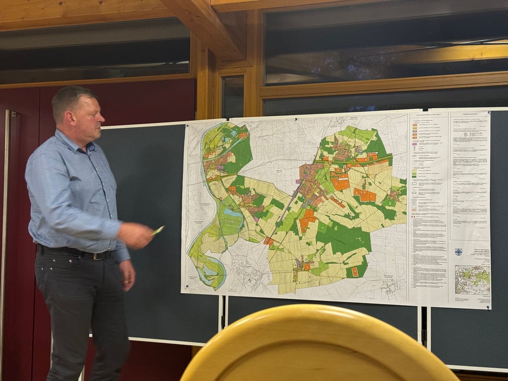 Bürgermeister Marko Simon vor dem Entwurf des Flächennutzungsplanes. Orange sind die Flächen für die geplanten Photovoltaikanlagen innerhalb der Einheitsgemeinde Möser.