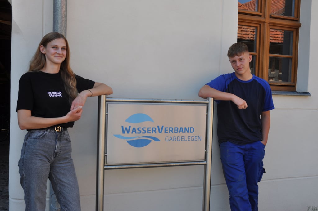 Das Logo des Wasserverbandes Gardelegen am Verwaltungsgebäude des Verbandes im Alten Hospital, hier mit den Azubis Lisa Kaczensky aus Kunrau und Justin Storbeck aus Bismark.