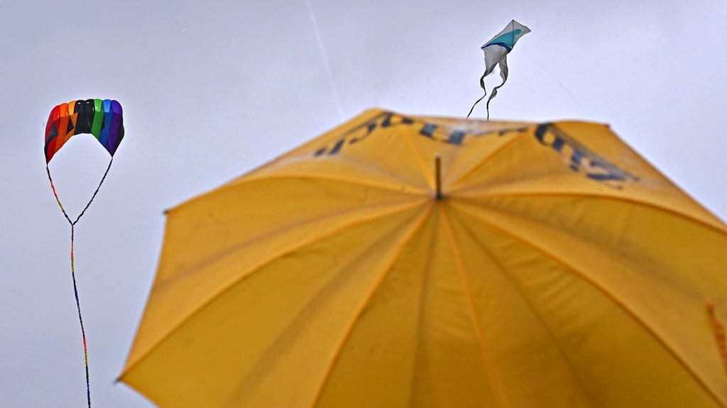 Regen, Regen, Regen - Wagemutige lassen beim Drachenfest auf dem Flugplatz trotzdem ihre Drachen steigen.