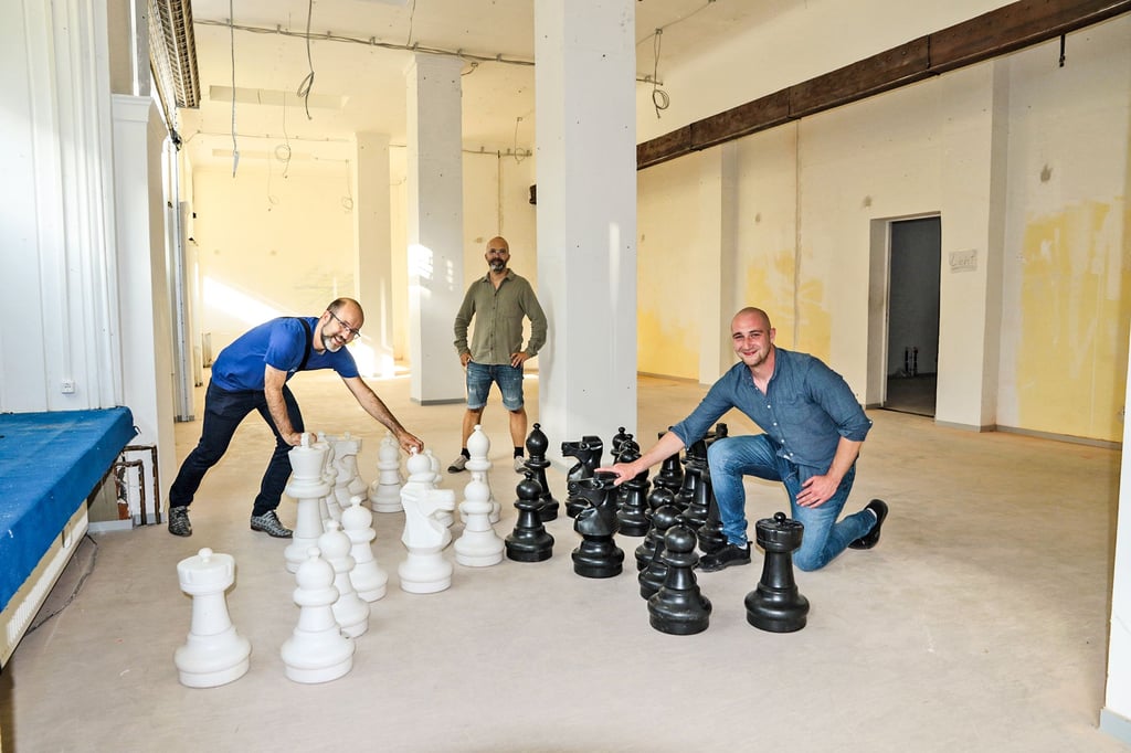 Jens Windelband (l.), Michael Zeuner und  Vilen Rafayevych vom Verein Schachzwerge Magdeburg  haben hier schonmal Figuren in dem noch leeren Ladenlokal aufgebaut.