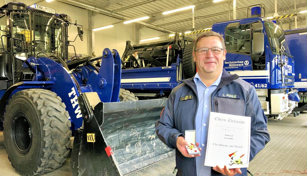 Lars Pohle, der Ortsbeauftragte des THW Merseburg, zeigt stolz die Auszeichnung des Kreisfeuerwehrverbandes Saalekreis.