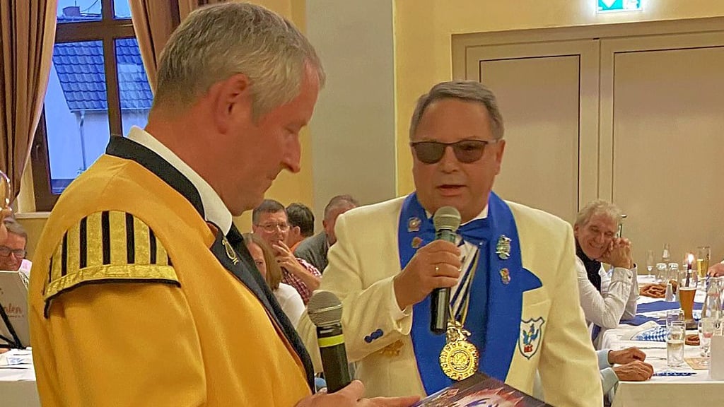 Der Ehrenpräsident des HKC, Uwe Gäbelein, gratuliert Spielmannszugchef Markus Meske.