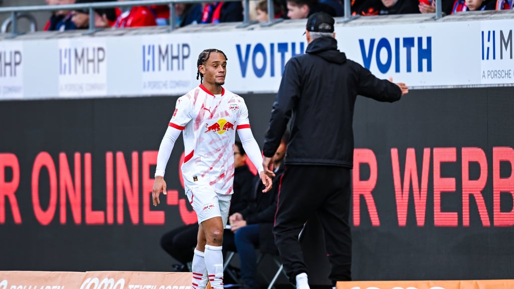 Xavi Simons geht nach seiner Auswechslung zu Trainer Marco Rose.