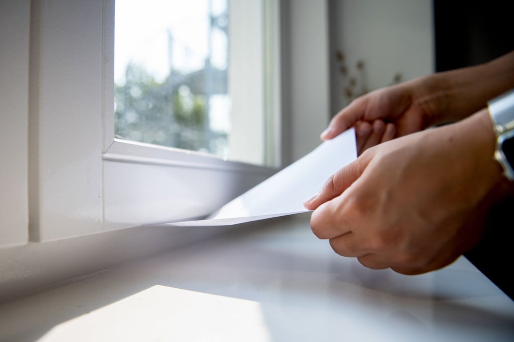 So findet man heraus, ob ein Fenster dicht ist: Ein eingeklemmtes Blatt Papier sollte fest sitzen.