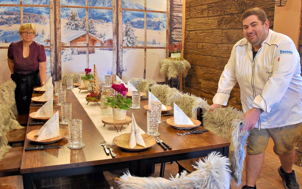 Im Dirndl und der Lederhose decken Heike Claus und Sascha Oldenburg den Tisch in der „Lilo-Alm“ ein. Sie steht sinnbildlich für das, was künftig Standard sein soll im Restaurant der „Villa Lilo“. Unter dem Namen „Heikes gute Stube“ – benannt nach der guten Seele des Hauses, Heike Claus – eröffnet es im November neu.