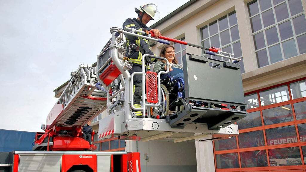 Stendaler Feuerwehrmann Robin Stoppa zeigt Annemarie Kock, wie sich eine Rollstuhl-Rettung anfühlt.