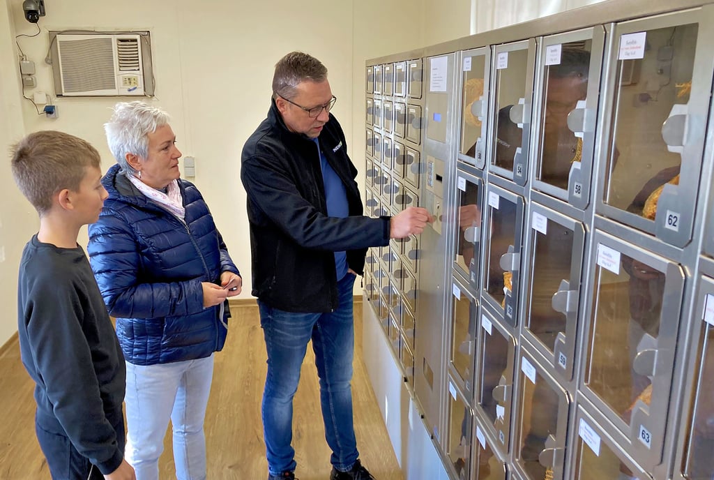 Yves Blume, Geschäftsführer der Barbyer Agrar GmbH, zeigt Kundin Doreen Gortol, wie der Kartoffel-Automat funktioniert.