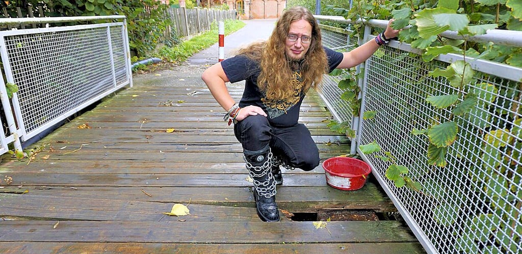 Paul Kramer zeigt die gefährlichste Stelle der Brücke: hier ist ein Stück Balken weggebrochen; notdürftig markiert mit einer Plastikschüssel.