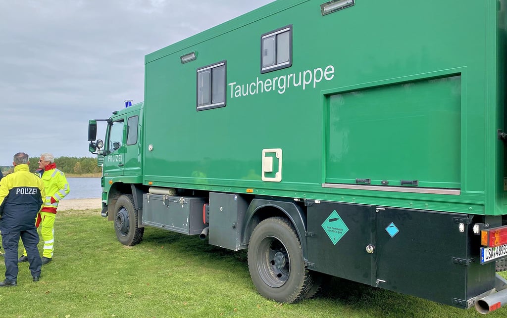 Das Fahrzeug der  Tauchergruppe der Landespolizei am Strand des Badesees Dixförda. Acht Taucher und drei Beamte zur Sicherstellung waren am Montag aus Magdeburg angereist, um den Vermissten zu finden.