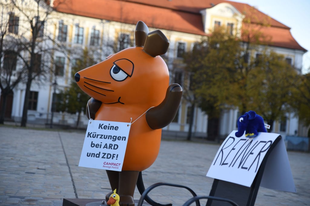 Die von Aktivisten "entführte" Maus protestiert in Magdeburg gegen Kürzungen beim öffentlich-rechtlichen Rundfunk.
