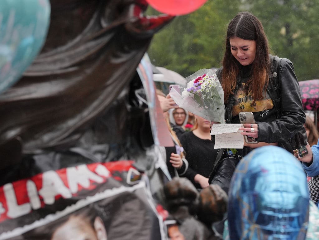 Fans legten Blumen und Briefe nieder und hielten Ballons.