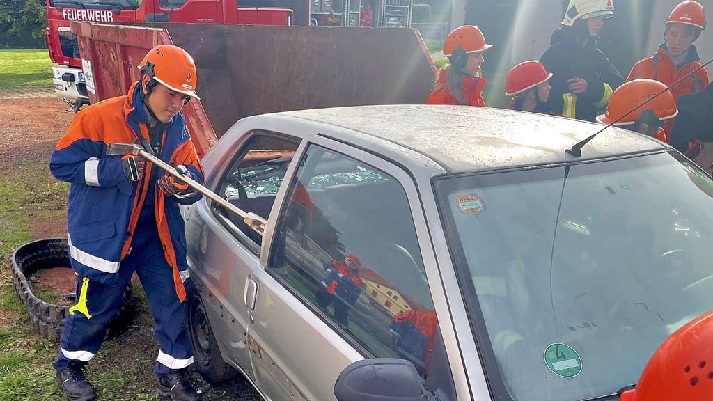 Eine Person steckt noch im Unfallauto. Die Jugendlichen versuchen, das Auto zu öffnen.