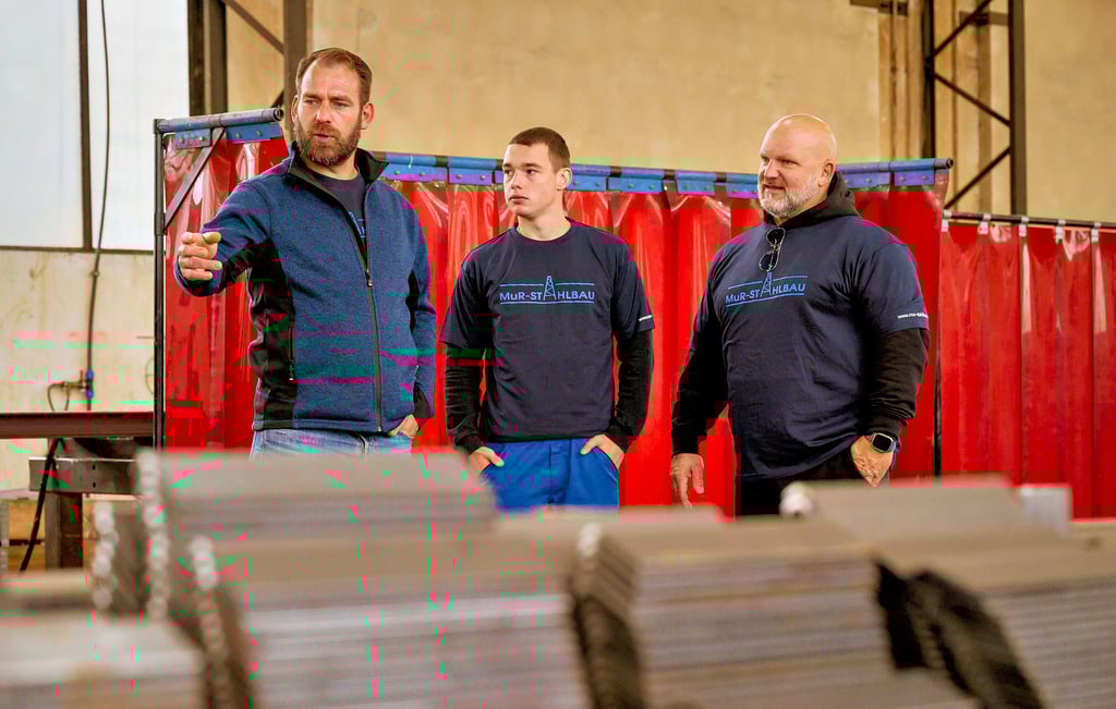 Mario Schirner (l.), Technischer Leiter bei der MuR Stahlbau GmbH, führt Luis Gentzsch und Lutz Schweigel durch eine der Hallen.