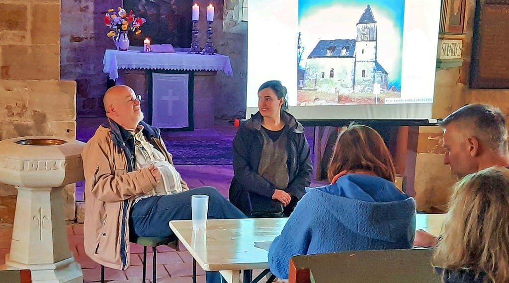 Über die Geschichte der Kirche St. Georg tauschten sich der ehemalige Pfarrer Udo Becker und seine Nachnachfolgerin Friederike Rohr aus. Im Hintergund ist ein Foto des Gotteshauses vor der Sanierung zu sehen ...