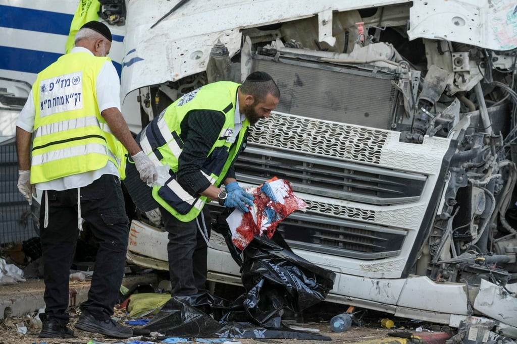 Mitglieder des Rettungs- und Bergungsteams Zaka arbeiten an der Stelle, an der ein Lkw-Fahrer eine Bushaltestelle gerammt und dabei Dutzende von Menschen verletzt hat.