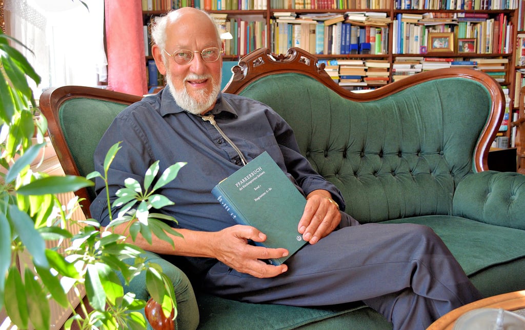 Pfarrer Norbert Lazay in seinem Arbeitszimmer in Gladigau. Sein ganzer Stolz ist das Buch zur Pfarrergeschichte.
